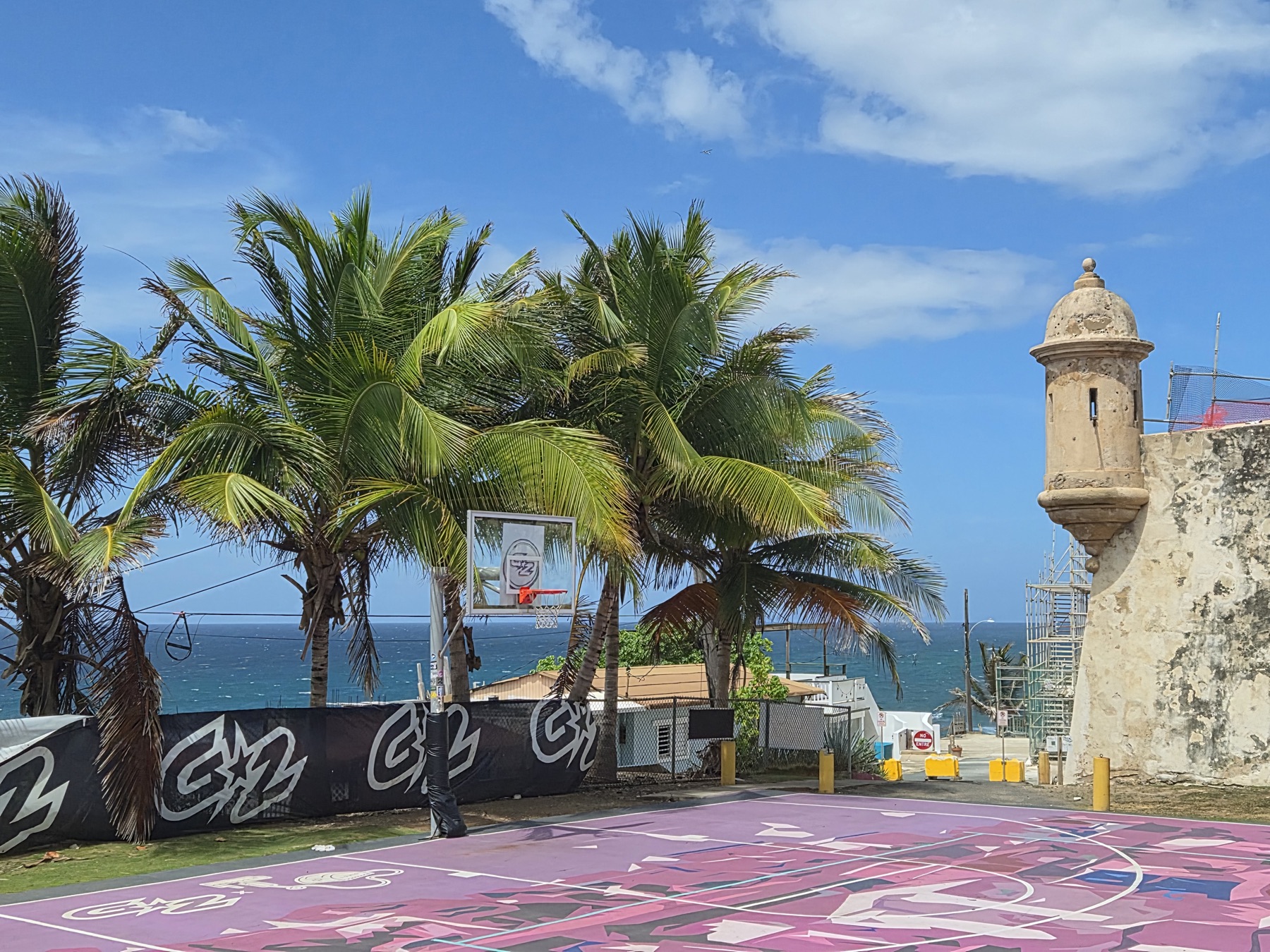 Community basketball court beside the historic walls and ocean in La Perla