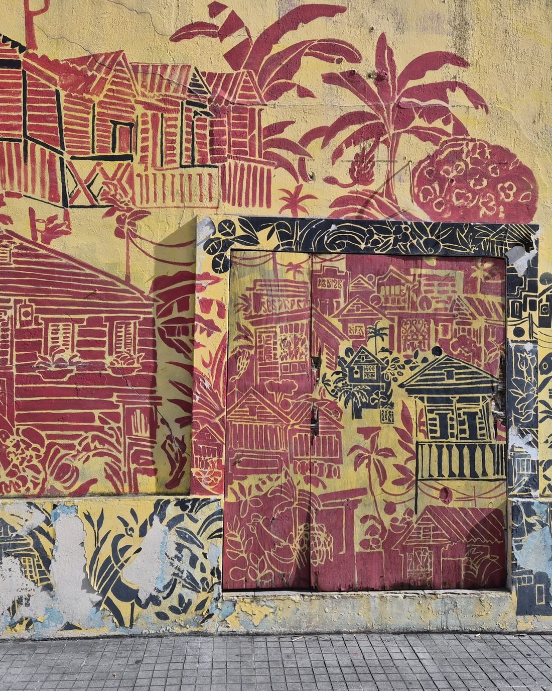 Mural of Puerto Rican wooden casitas and palms on a wall in Ponce